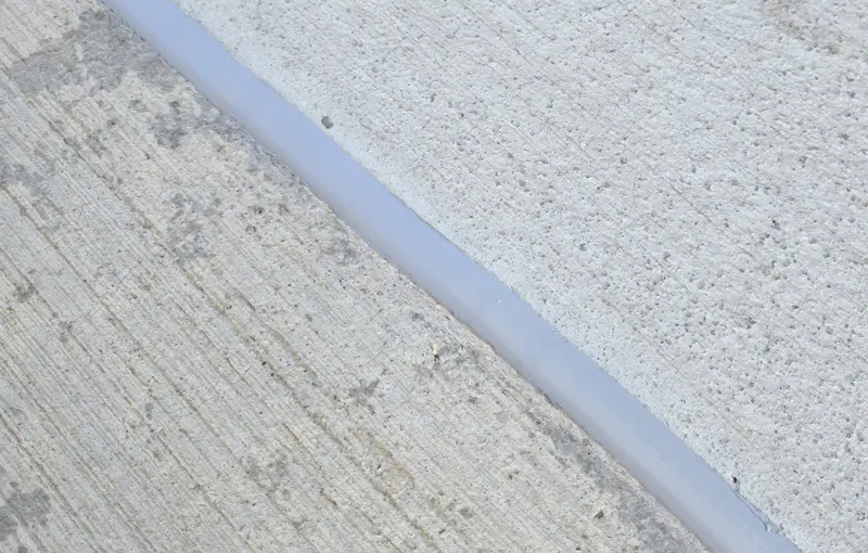 close up look at some sealant on a sidewalk.